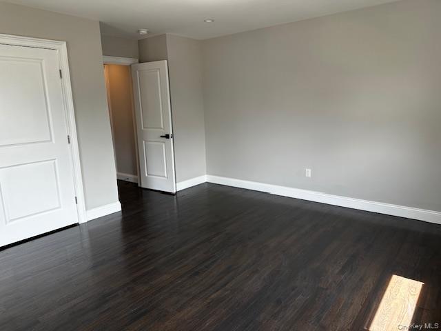 558 Oxford Road Cedarhurst, NY 11516 - Photo 7 of 22 Spare room with baseboards and dark wood-style flooring