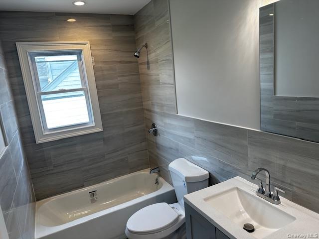 558 Oxford Road Cedarhurst, NY 11516 - Photo 8 of 22 Bathroom featuring shower combination, tile walls, vanity, and recessed lighting