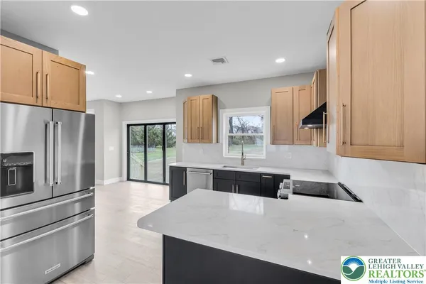 a kitchen with a sink a stove top oven and wooden floor