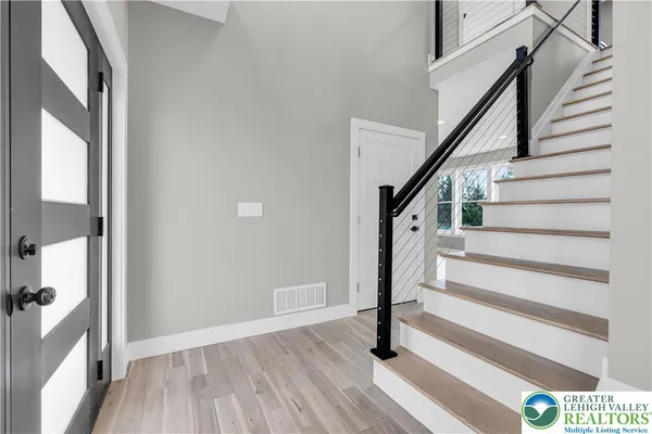 a view of entryway and hall with wooden floor