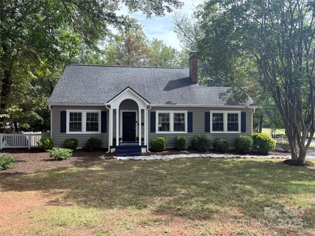 a front view of a house with yard and green space