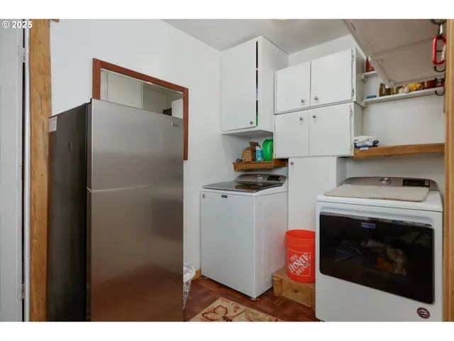 a kitchen with stainless steel appliances a refrigerator a stove and white cabinets