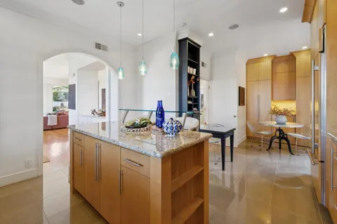 a spacious bathroom with a granite countertop sink a mirror and a bath tub