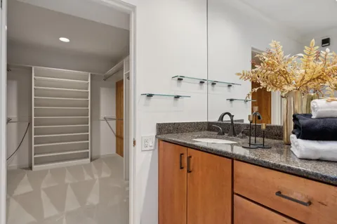 a bathroom with a granite countertop sink and a mirror
