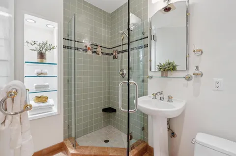 a bathroom with a sink mirror and shower