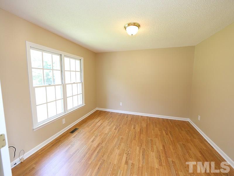 7408 Wiley Mangum Road Bahama, NC 27503 - Photo 2 of 13 an empty room with wooden floor and windows