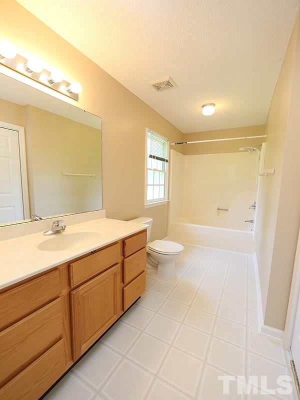 7408 Wiley Mangum Road Bahama, NC 27503 - Photo 9 of 13 a spacious bathroom with a granite countertop sink a toilet and a mirror