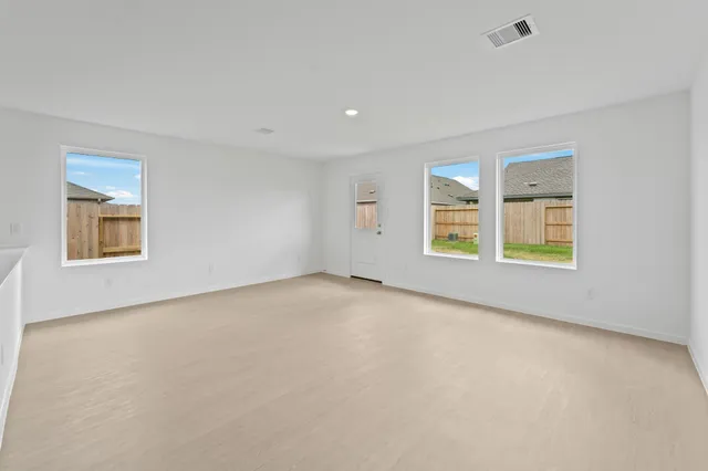 a view of an empty room with a window and closet area