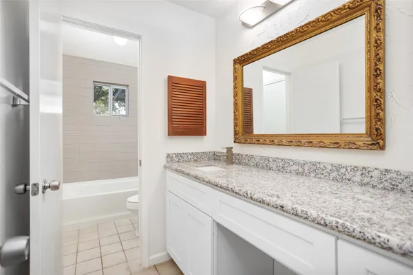 a bathroom with a granite countertop sink and a mirror