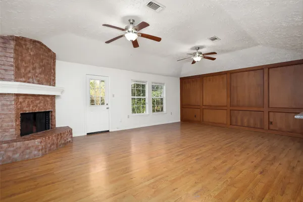 a view of an empty room with a fireplace and a window