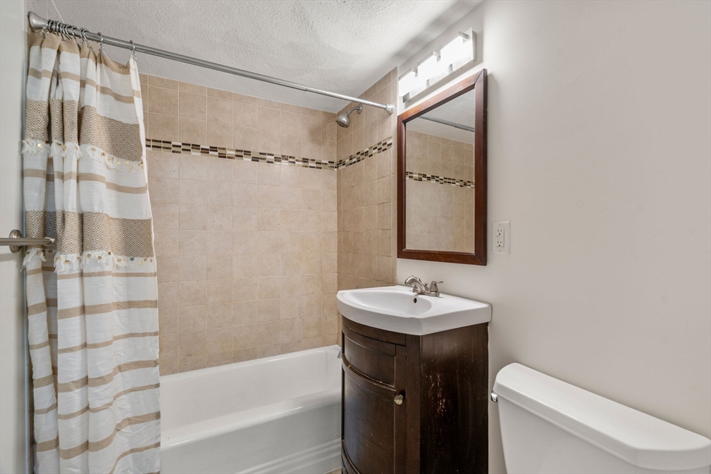 1105 Lexington Street, Unit 41 Waltham, MA 02452 - Photo 11 of 19 a bathroom with a sink a toilet and shower