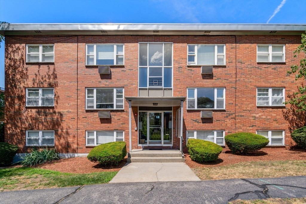 1105 Lexington Street, Unit 41 Waltham, MA 02452 - Photo 17 of 19 front view of a brick house with a yard