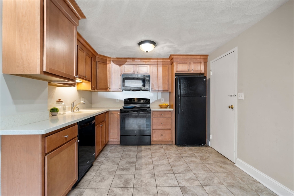 1105 Lexington Street, Unit 41 Waltham, MA 02452 - Photo 5 of 19 a kitchen with stainless steel appliances granite countertop a refrigerator stove and sink