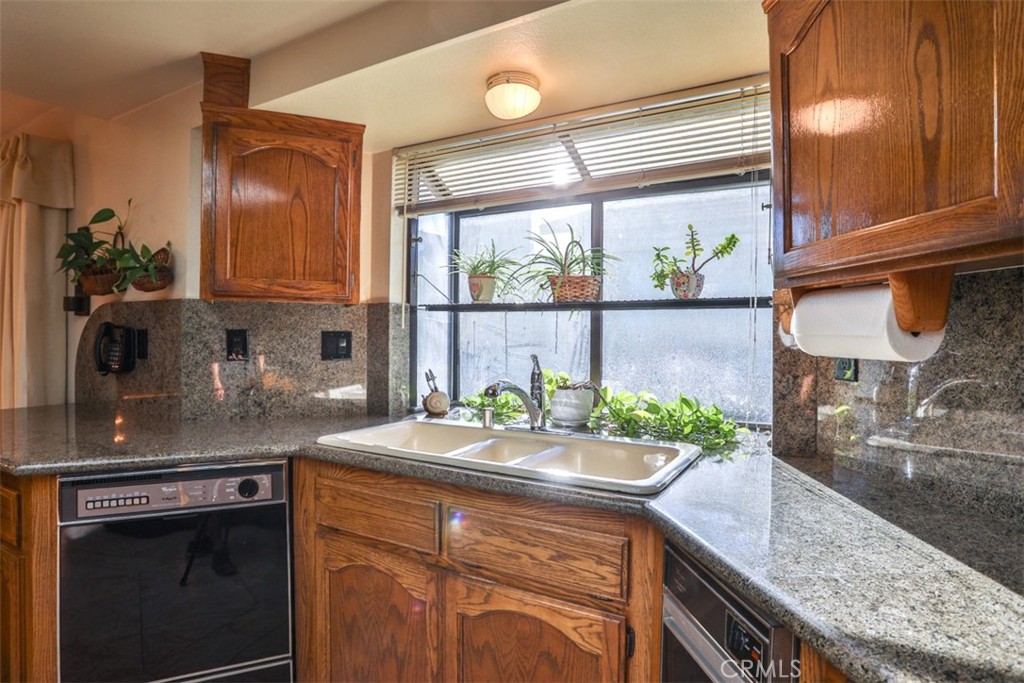 5848 Burlwood Court Rancho Cucamonga, CA 91701 - Photo 43 of 71 a kitchen with stainless steel appliances granite countertop a sink a stove and a wooden cabinets