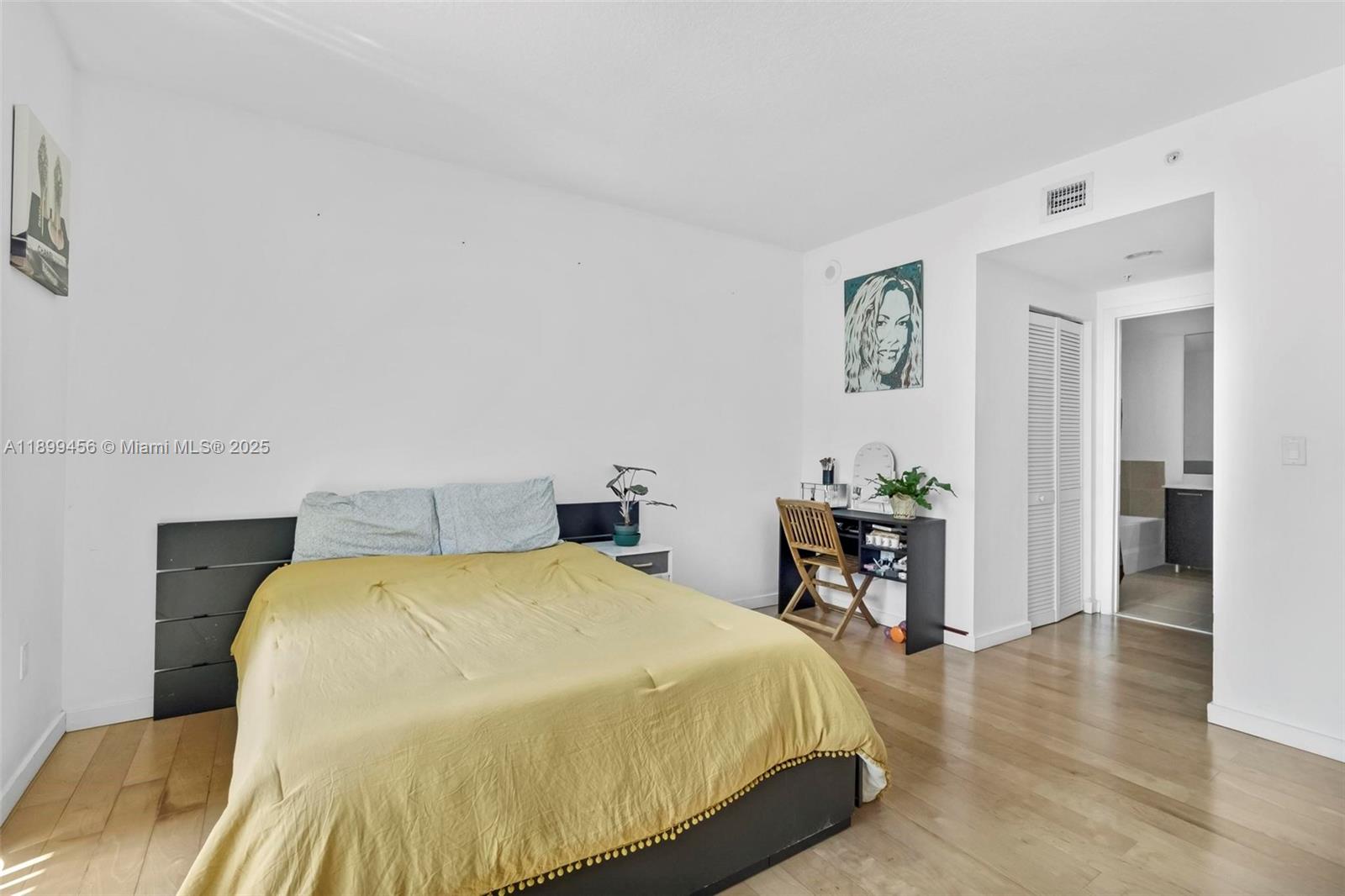 333 Northeast 24th Street, Unit 812 Miami, FL 33137 - Photo 11 of 32 a bedroom with a bed and a table in it