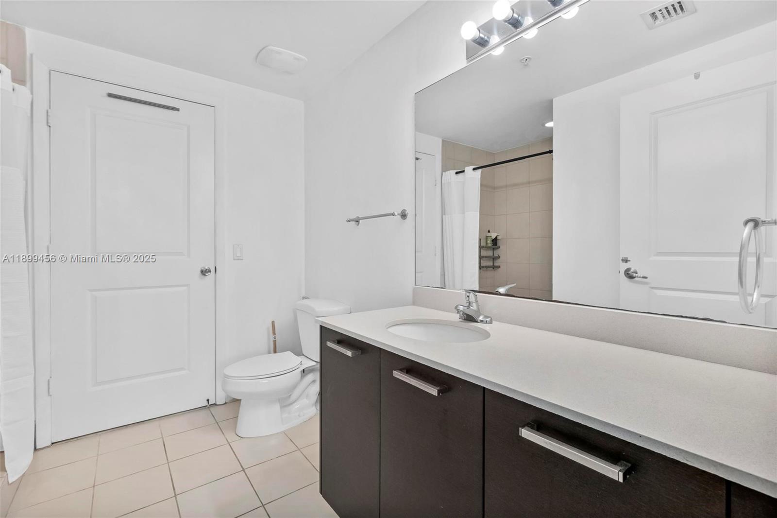 333 Northeast 24th Street, Unit 812 Miami, FL 33137 - Photo 21 of 32 a bathroom with a sink a toilet and a mirror