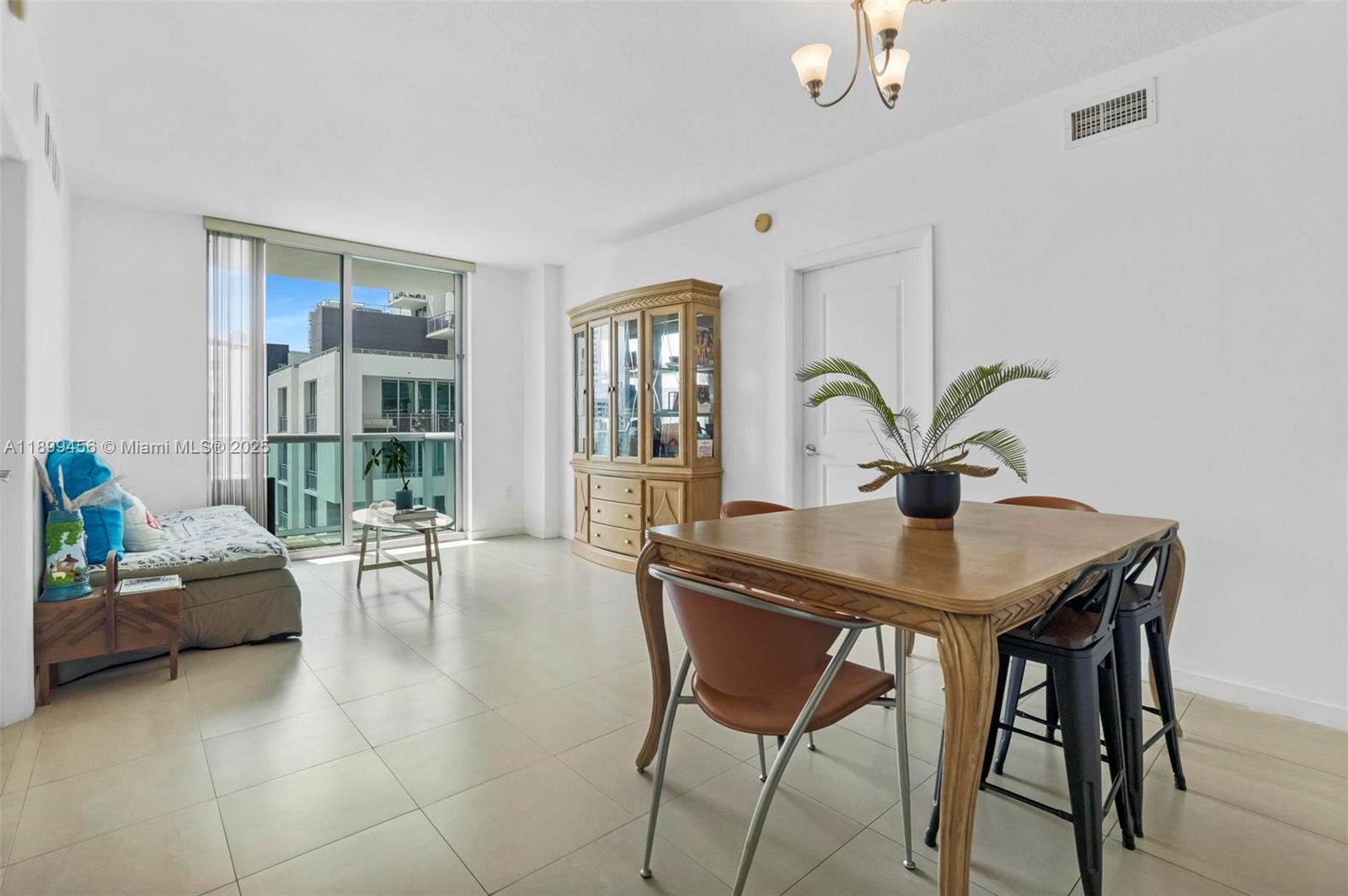 333 Northeast 24th Street, Unit 812 Miami, FL 33137 - Photo 22 of 32 a living room with furniture a potted plant and a large window