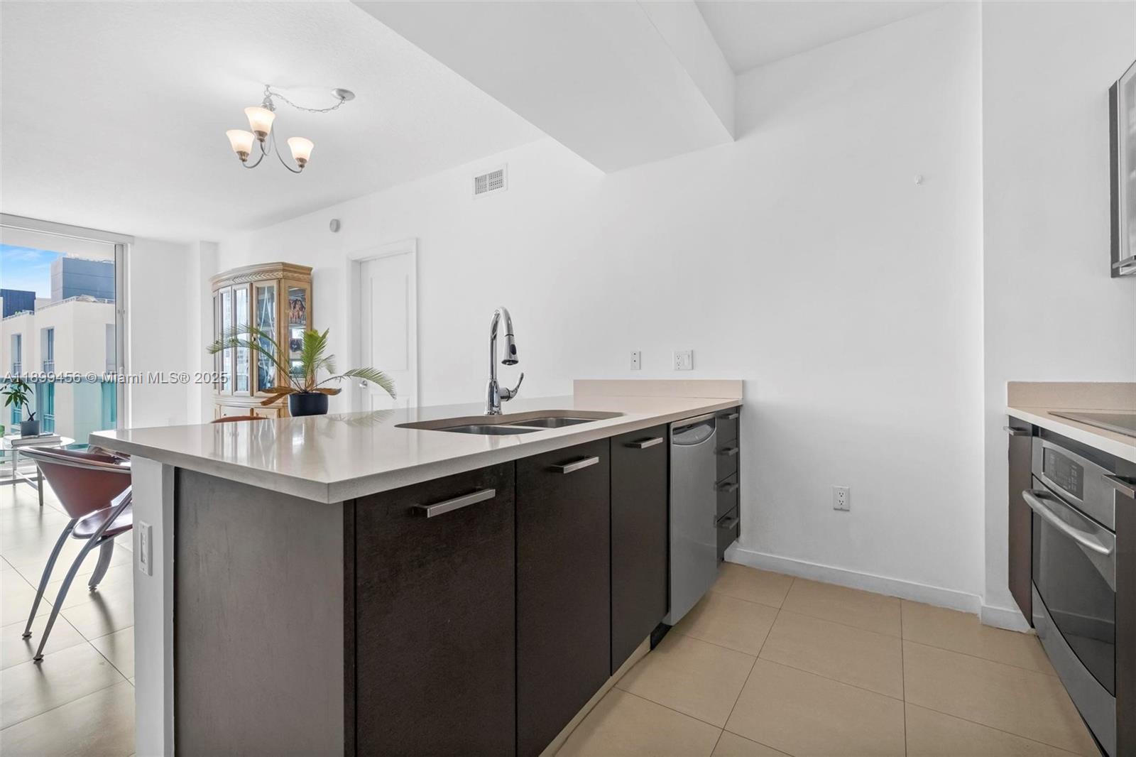 333 Northeast 24th Street, Unit 812 Miami, FL 33137 - Photo 3 of 32 a kitchen with a sink and a refrigerator