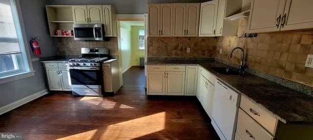 a kitchen with stainless steel appliances granite countertop a refrigerator stove and sink