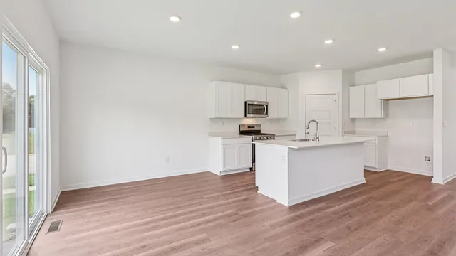a kitchen with white cabinets and appliances