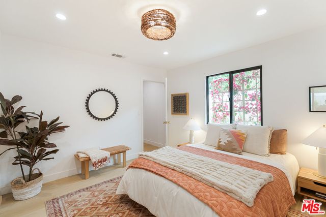 a bedroom with bed and a potted plant