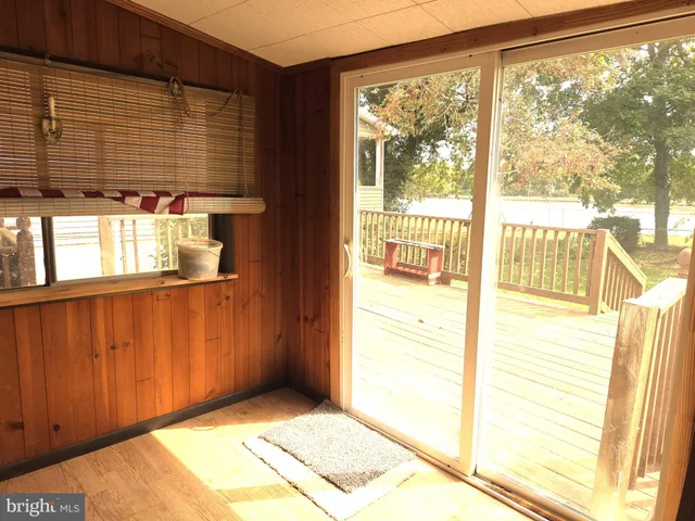 a view of an empty room with wooden floor and windows