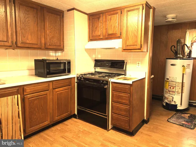 a kitchen with stainless steel appliances granite countertop a stove a sink and a microwave