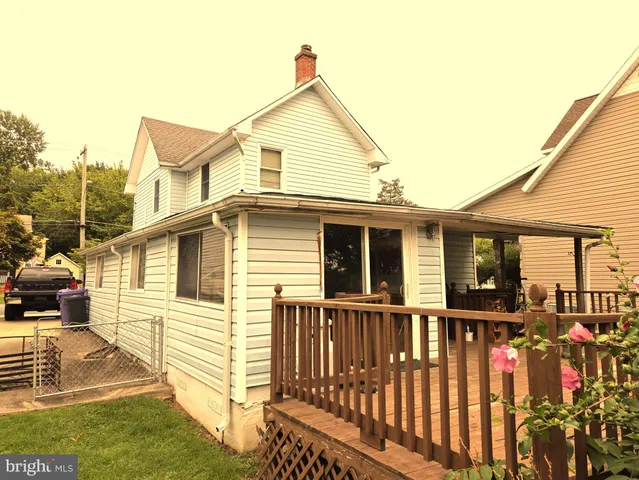 a view of a white house with large windows and a yard