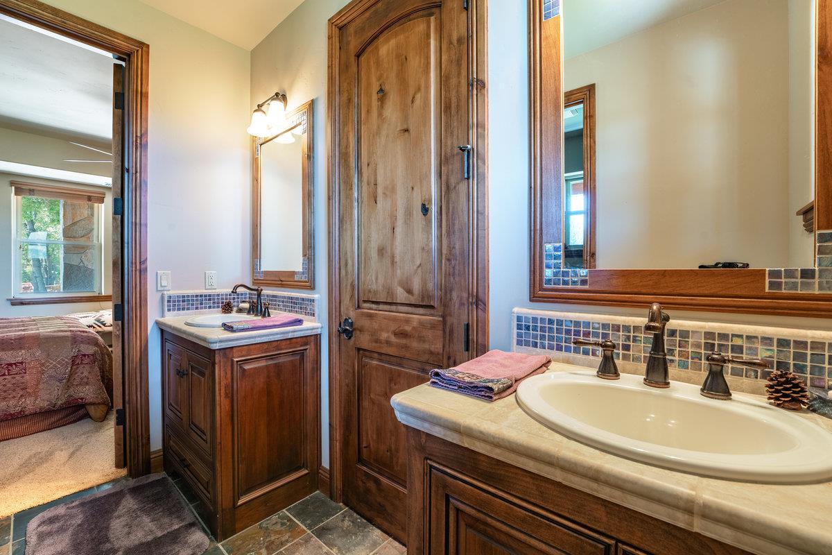 39110 Kearsarge Mill Road Alta, CA 95715 - Photo 64 of 99 a bathroom with a granite countertop sink and a mirror