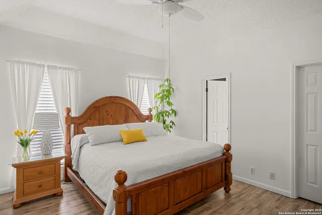a bedroom with a bed and a dresser with wooden floor