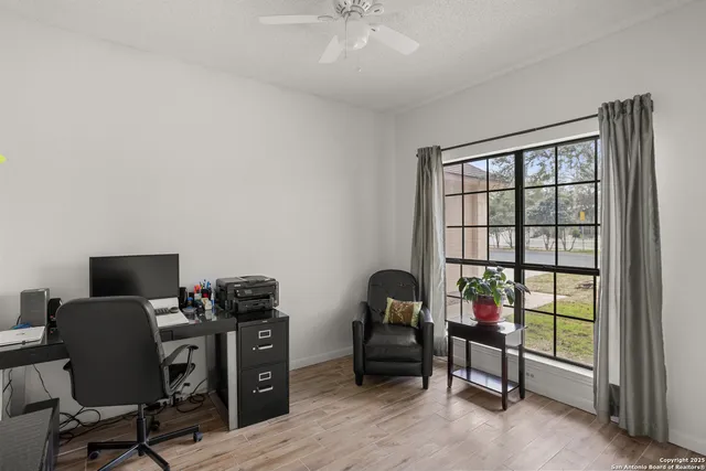 a view of a workspace with furniture and a window