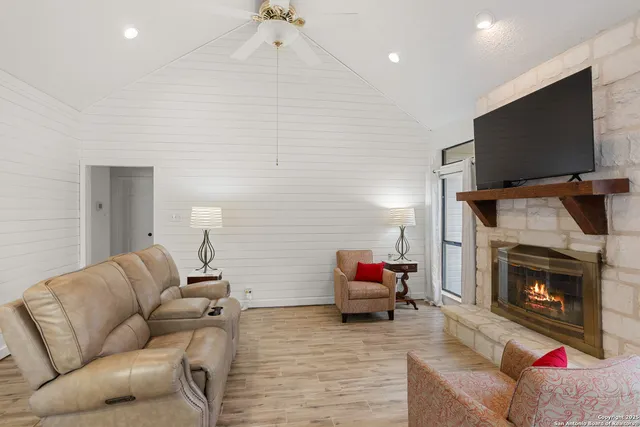a living room with furniture a flat screen tv and a fireplace