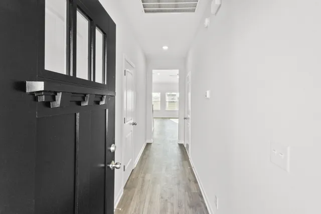 a view of a hallway with wooden floor and staircase