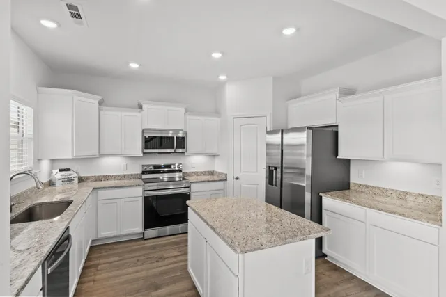 a kitchen with a sink stainless steel appliances and white cabinets