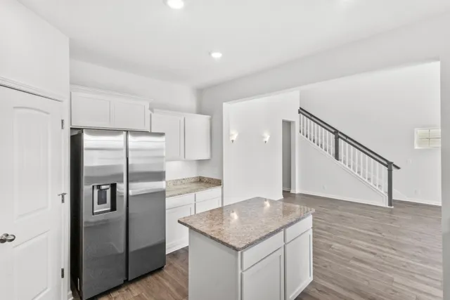 a kitchen with stainless steel appliances granite countertop a refrigerator a sink and a stove