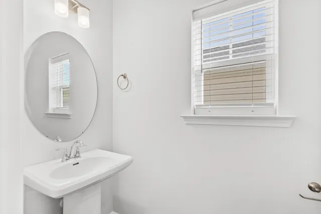 a bathroom with a sink a mirror and a window