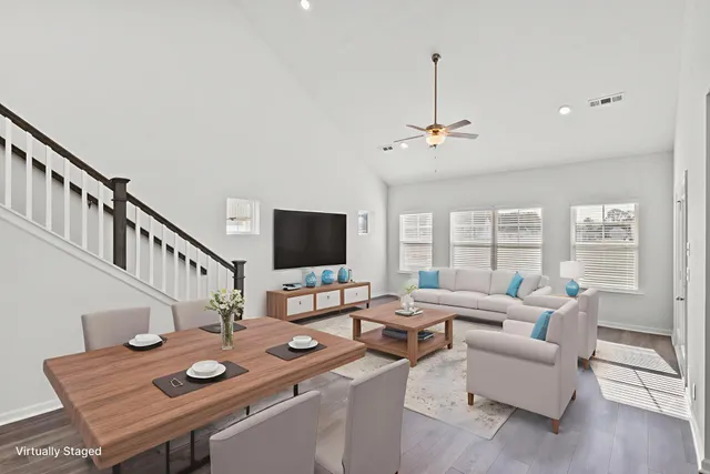 a living room with furniture a flat screen tv and a large window