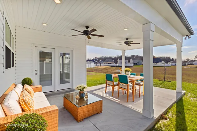 a living room with patio furniture and a floor to ceiling window