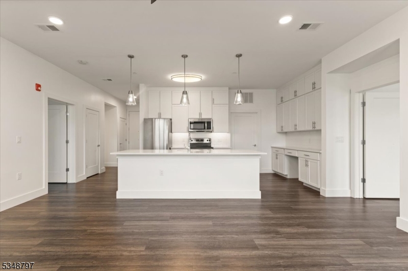 450 Springfield Avenue, Unit 301 Berkeley Heights, NJ 07922 - Photo 3 of 26 a view of kitchen with kitchen island stainless steel appliances refrigerator oven and cabinets