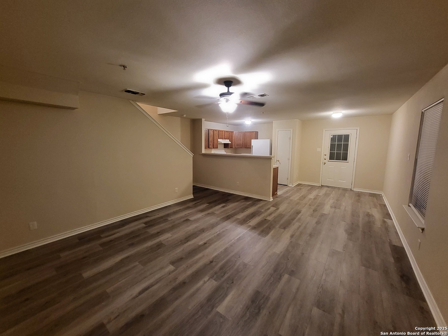 10006 Vasso View, Unit 4 Converse, TX 78109 - Photo 4 of 15 an empty room with wooden floor chandelier fan and windows