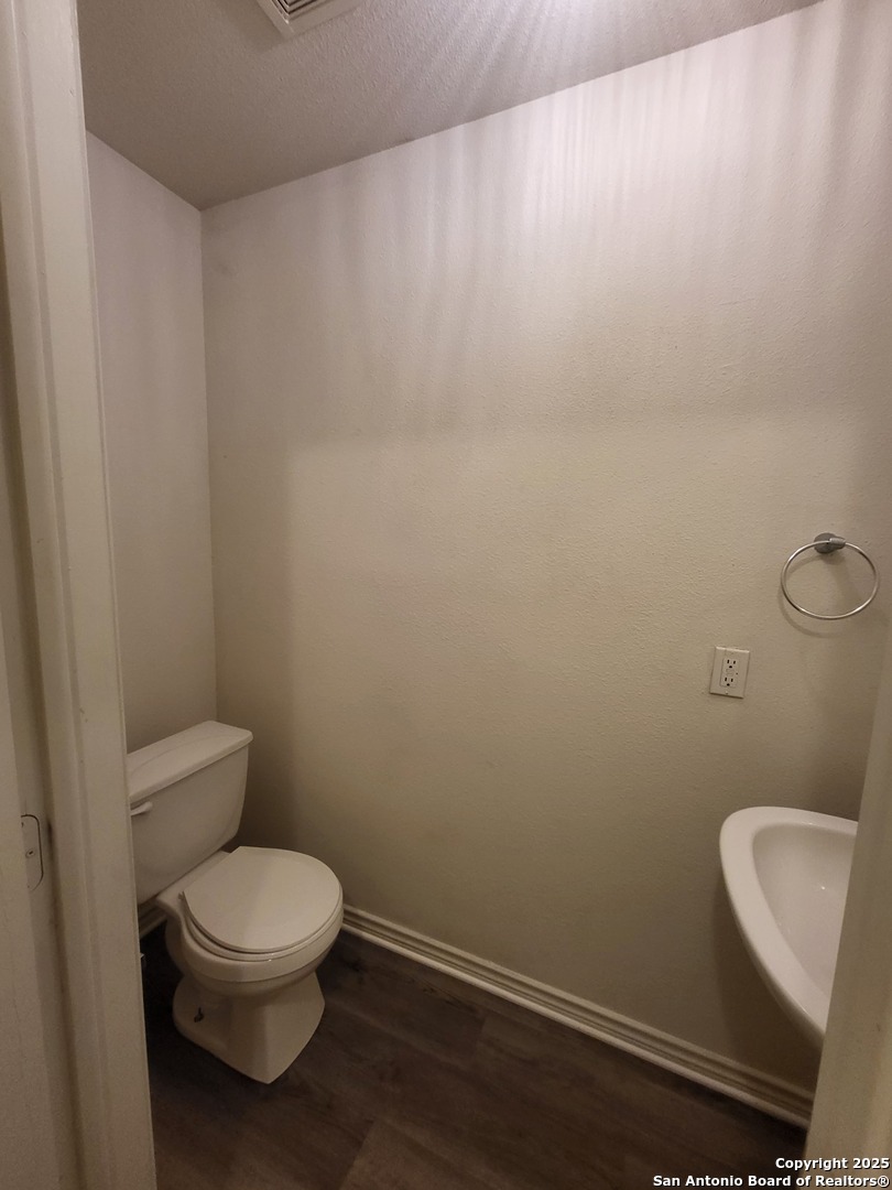 10006 Vasso View, Unit 4 Converse, TX 78109 - Photo 5 of 15 a white toilet sitting next to a white sink and vanity