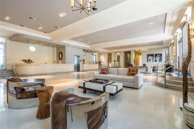 a living room with couches and kitchen view with wooden floor