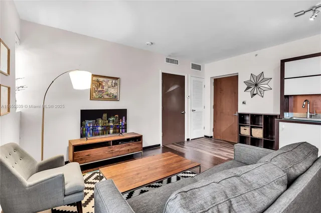 a living room with furniture and wooden floor