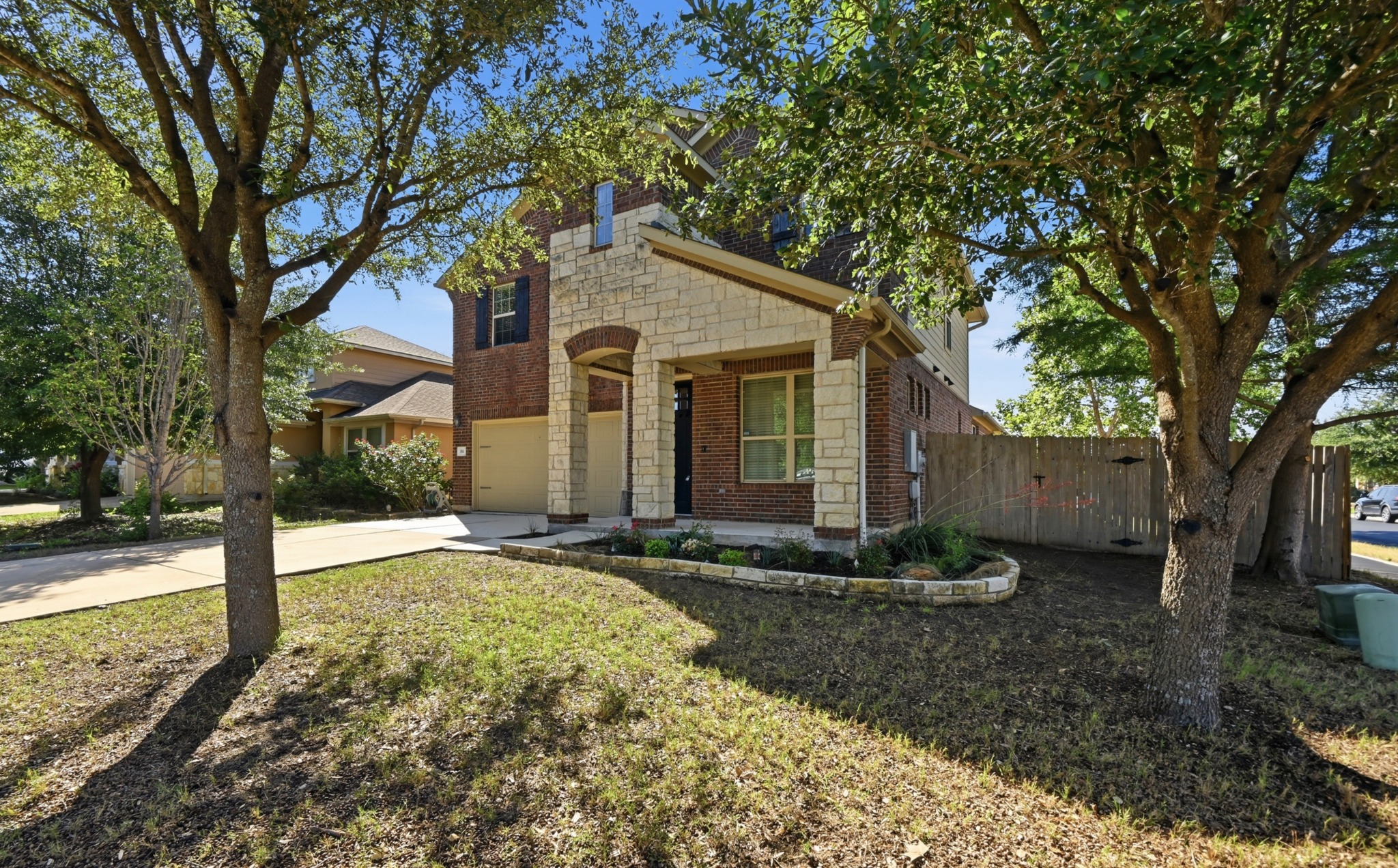 351 Wincliff Drive Buda, TX 78610 - Photo 3 of 40 A classic brick and stone facade welcomes you to this charming residence, framed by mature shade trees.