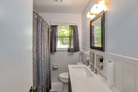 a bathroom with a sink toilet and window