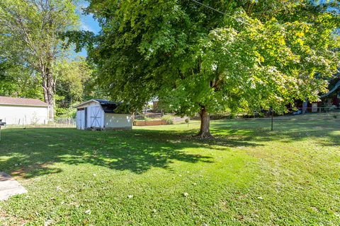 a backyard of a house with lots of green space and fountain