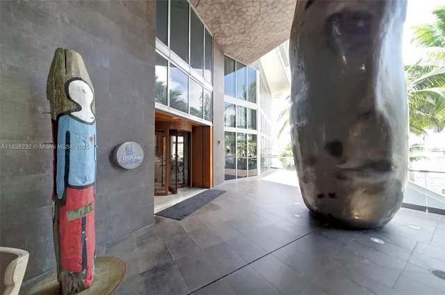 a living room with furniture a rug kitchen view and a large window