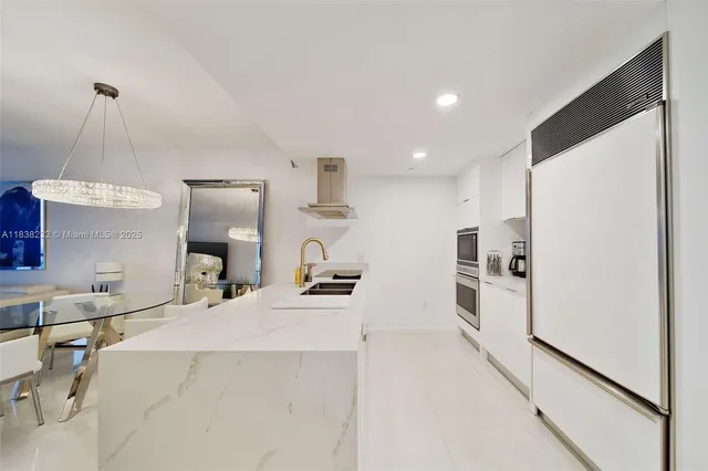 a kitchen that has a sink a refrigerator and a stove top oven