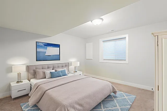 a bedroom with a bed and a painting on the wall