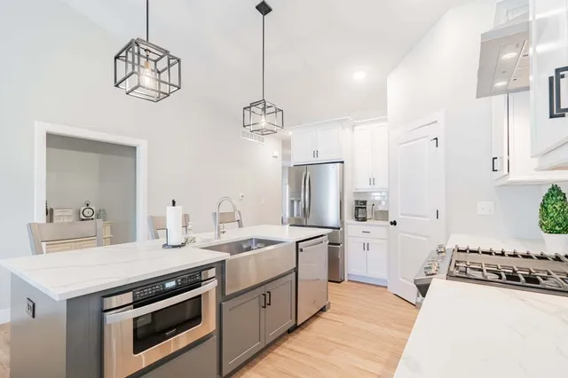 a kitchen with stainless steel appliances a stove a sink and a refrigerator